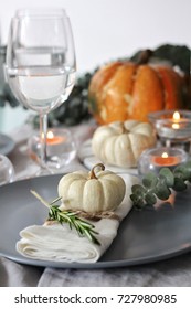 Seasonal Autumn Table Decoration With Pumpkin, Rosemary, Leaves And Candles