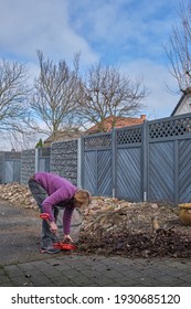 Seasonal Garden Work. Woman Cleaning A Path Way To A Detached House