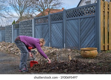 Seasonal Garden Work. Woman Cleaning A Path Way To A Detached House