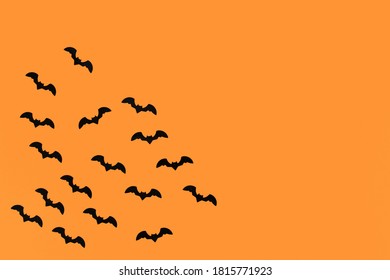 Seasonal Halloween Deco Confetti In Shape Of Small Flying Black Bats In Corner Of Orange Background With Empty Copy Space