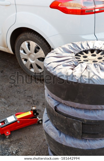 seasonal replacement of car tyres with jack\
outdoors - set of summer\
tyres