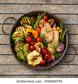 Seasonal, summer eating concept. Grilled vegetables and chicken breast in a pan on a wooden table. Top view flat lay background - Powered by Shutterstock