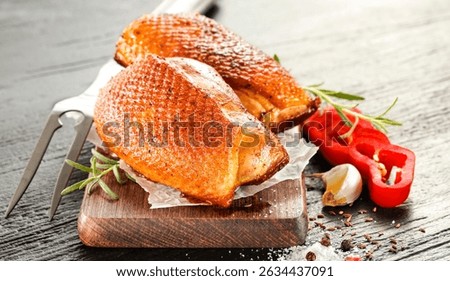 Seasoned pieces of grilled meat placed on a kitchen table surrounded by fresh ingredients, vegetables and herbs. Healthy eating, home cooking, food blogs and conscious food preparation concept.