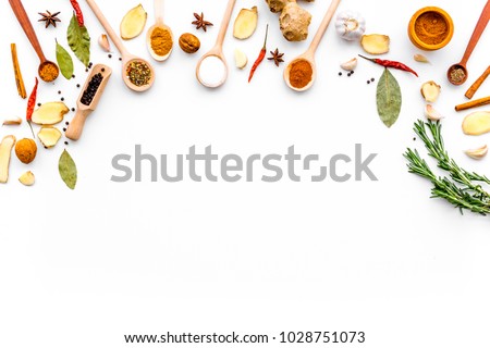 Seasoning background. Dry spices near ginger, garlic, rosemary, laurel leaf on white background top view copy space
