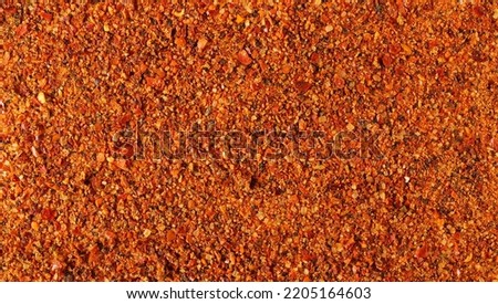 Seasoning preparation, mild hot powder mixture, with spices and tomatoes, (black pepper, garlic, cane sugar, granulated tomatoes, cayenne pepper, sea salt) background and texture 