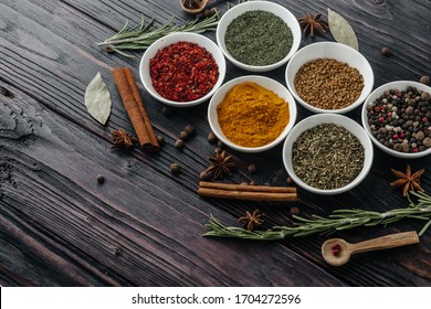 Seasonings with fresh and dried herbs in bowls on an old wooden background. Free space to copy. Indian cuisine.
