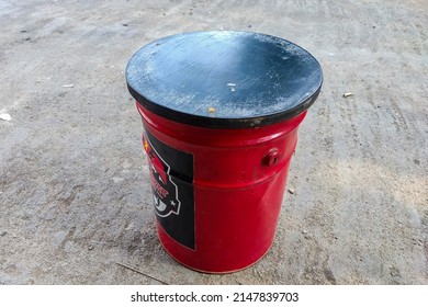 A Seat From An Old Paint Can In Red And Black.