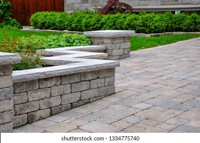 A Seat Wall With Pillars And Natural Stone Coping Helps Define A Tumbled Paver Driveway And Is A Beautiful Landscaping Feature.