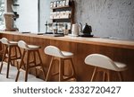 Seat and wooden counter with coffee equipment on counter bar and wooden shelf on rough cement wall. design for cafe or home