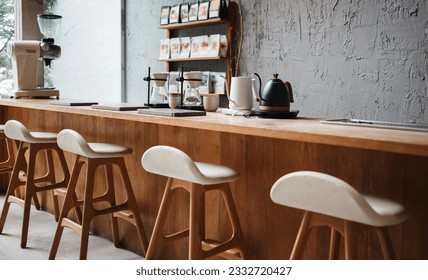 Photo of Seat and wooden counter with coffee equipment on counter bar and wooden shelf on rough cement wall. design for cafe or home
