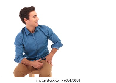 Seated Casual Young Man Laughing And Looks To Side On White Background