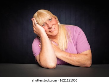 Seated Portrait Of A Blonde Trans Woman Resting Head On Her Hand