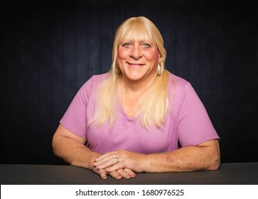 Seated portrait of a smiling blonde trans woman