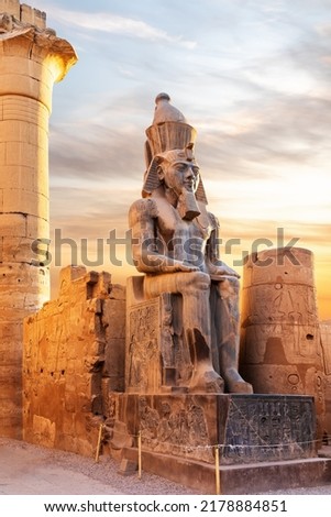 Seated statue of Ramesses II by the Luxor Temple entrance, sunset scenery, Egypt