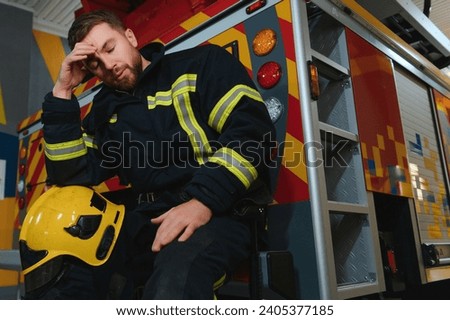 A seated and sweating firefighter is exhausted, distressed and tired after being overwhelmed in a rescue operation.