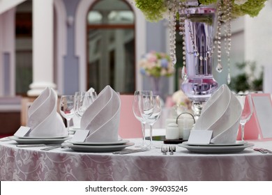 Seating card for wedding table. Wine glasses with napkins set in restaurant.