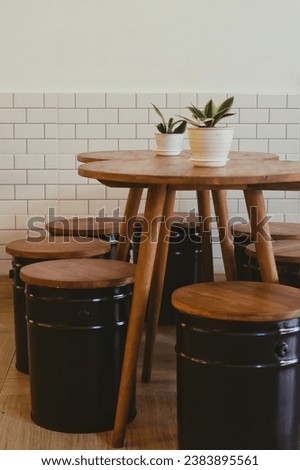 a seating set consisting of several wooden tables and small benches made from used paint barrels. Selective focus.