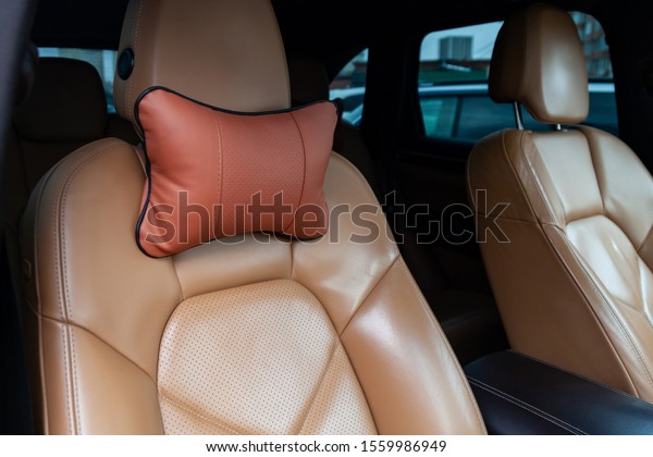 The seats in\
the car are made of brown leather with pillows for the neck and\
rest during long trips and\
travels.