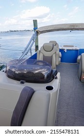 Seats And Steering Wheel On A Flat Pontoon Boat On The Water