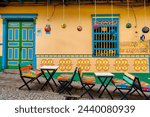 Seats and tables in front of a typical colorful house in Guatape, Colombia