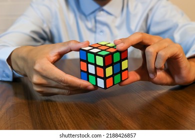 Seattle - Aug8 2022: Businessman Solving A Rubik's Cube. Example Of Problem And Puzzle Solving. Solve Rubix Cube.