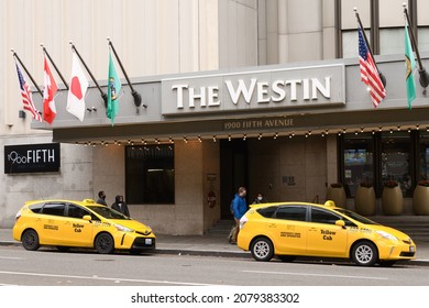 Seattle - November 21, 2021; The Westin hotel in the downtown area of Seattle.  Two yellow cab taxis wait outside the entrance with flags on the awning