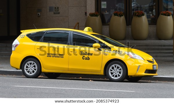 Seattle - November 21, 2021; A Yellow Cab taxi\
parked alongside a street curb in the downtown district of Seattle\
with rate panel on door