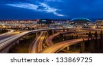 Seattle panorama of freeways under a deep blue evening sky and twinkling city lights at twilight