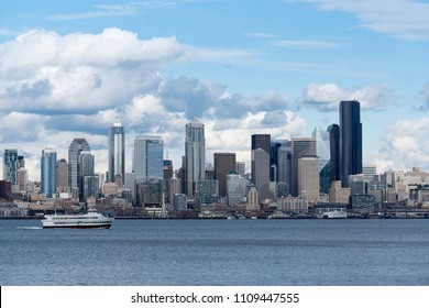The Seattle skyline viewed from across Elliott bay with partly cloudy blue sky - Shutterstock ID 1109447555