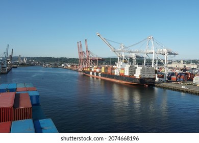 Seattle, USA 07 12 2021 Merchant Container Ship Moored In Container SSA Terminal To Be Load And Discharged By Gantry Cranes Operated By Stevedores Who Unlashing And Securing Twist Locks And Bars