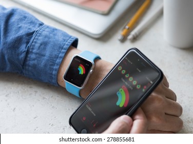 SEATTLE, USA - May 17, 2015: Man Using Activity App On Apple Watch To See Calories Burned During Day. Comparing Watch And  IPhone Statistics.