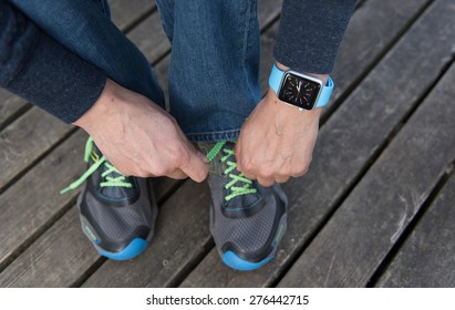 SEATTLE, USA - May 8, 2015: Man Tying His Sneakers While Wearing Apple Watch.