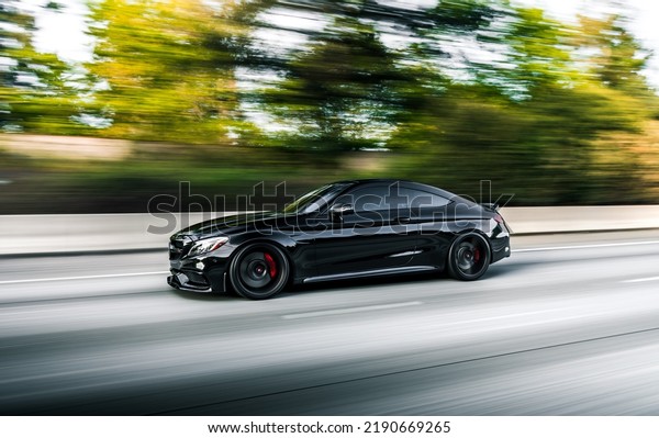 Seattle, WA,\
USA\
August 12, 2022\
Black Mercedes C63 S driving on the highway\
showing the drivers side of the\
car