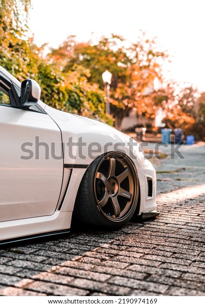 Seattle,\
WA, USA\
August 14, 2022\
White Subaru WRX parked on a stone paver\
street showing the passenger front of the\
car