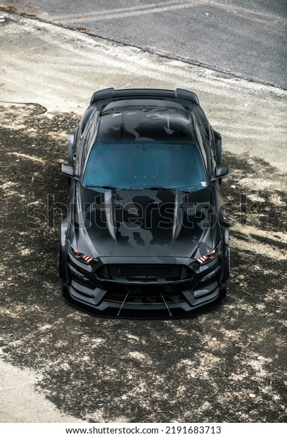 Seattle, WA,\
USA\
August 18, 2022\
Widebody Ford Mustang with a camouflage vinyl\
wrap parked and viewed from\
above