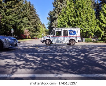 Seattle, WA / USA - Circa April 2020: Street View Of A USPS Mail Truck In A Seattle Area Neighborhood, Delivering Mail During The COVID-19 Pandemic.