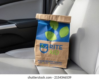 Seattle, WA USA - circa March 2022: Angled view of a brown paper Rite Aid bag sitting inside a car, with a prescription inside.
