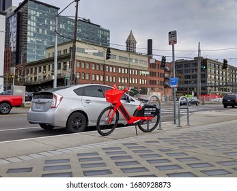 Seattle, WA / USA - Circa November 2019: Jump By Uber Ride Share Bike Parked On A Sidewalk Near To A Car Near Elliot Bay.