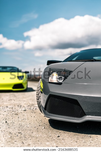 Seattle, WA, USA\
March 2, 2022\
Two Lamborghini\
Murcielagos parked on a gravel road showing the car in two\
different colors