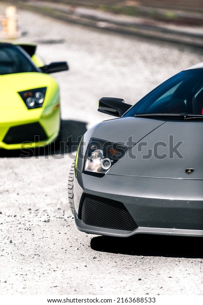 Seattle, WA, USA\
March 2, 2022\
Two Lamborghini\
Murcielagos parked on a gravel road showing the car in two\
different colors