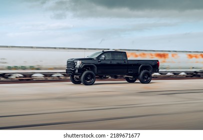 Seattle, WA, USA
March 4, 2022
Black GMC Sierra Denali Truck Driving Alongside A Train