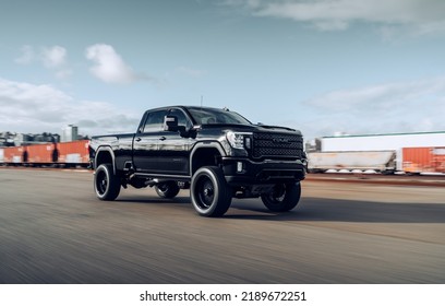 Seattle, WA, USA
March 4, 2022
Black GMC Sierra Denali Truck Driving Next To A Rail Line With Rail Cars