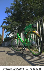 Seattle, Washington - July 31, 2019: Lime Pedal Bicycle Parked On Sidewalk Next To Totem Pole