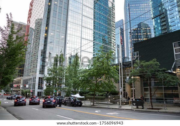 Seattle, Washington / USA -\
June 10 2020: Wide angle view of cop cars infront of the Seattle\
Police Department West Precinct, with skyscrapers in the\
background