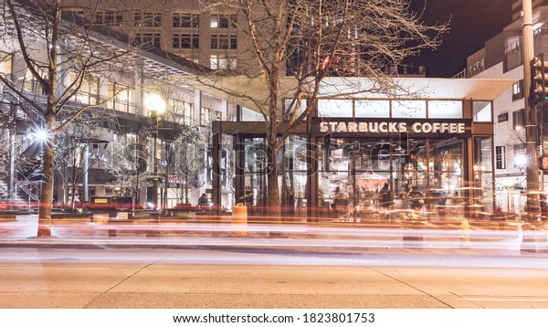 Seattle, Washington, USA -\
March 1, 2015_Nightlife in Seattle at stand-alone Starbucks coffee\
shop, long exposure photography for car light trails, old film look\
effect