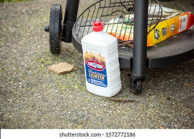 Seattle, Washington/United States - 10/24/2019: A View Of A Kingsford Charcoal Lighter Fluid Bottle Sitting Next To A Barbecue Grill In The Yard On The Ground.