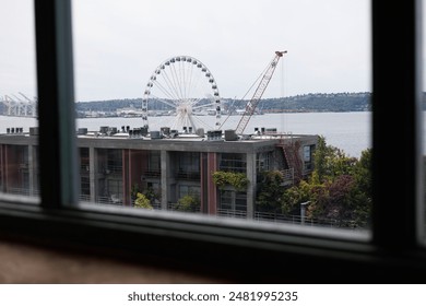 Seattle waterfront with ferris wheel, port cranes, and ferry in view. - Powered by Shutterstock