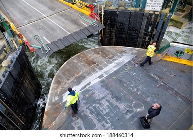 SEATTLE-APR 14, 2014: Washington State Ferry deckhands prepare a car ferry for landing in Seattle. WSF operates 22 ferries carrying more than 22 million passengers to 20 different ports of call. 