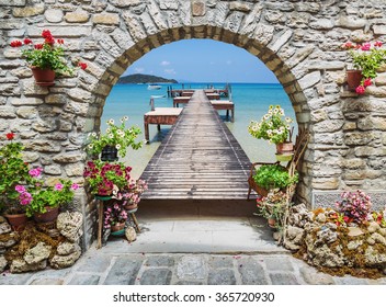 Seaview through the stone arch with flowers in Italy