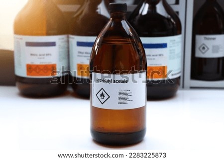 sec-Butyl acetate in glass,Hazardous chemicals and flammable symbols on containers in industry or laboratory 